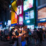 A street in Myeongdong at night, with shoppers and street food carts.