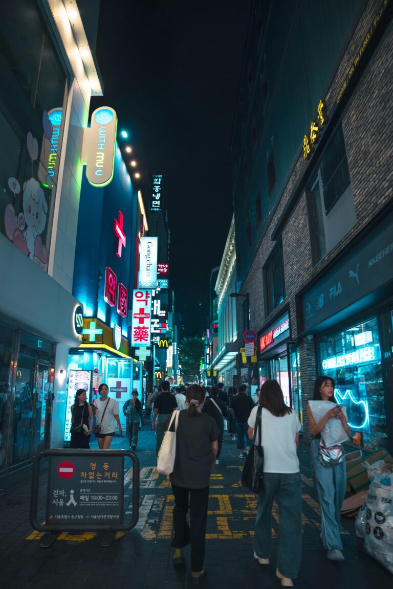 Women walking down a well-lit shopping street alone at night in Seoul, South Korea.