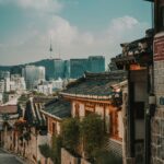 A street in Bukchon Hanok Village, Seoul, with Namsan Tower in the background.