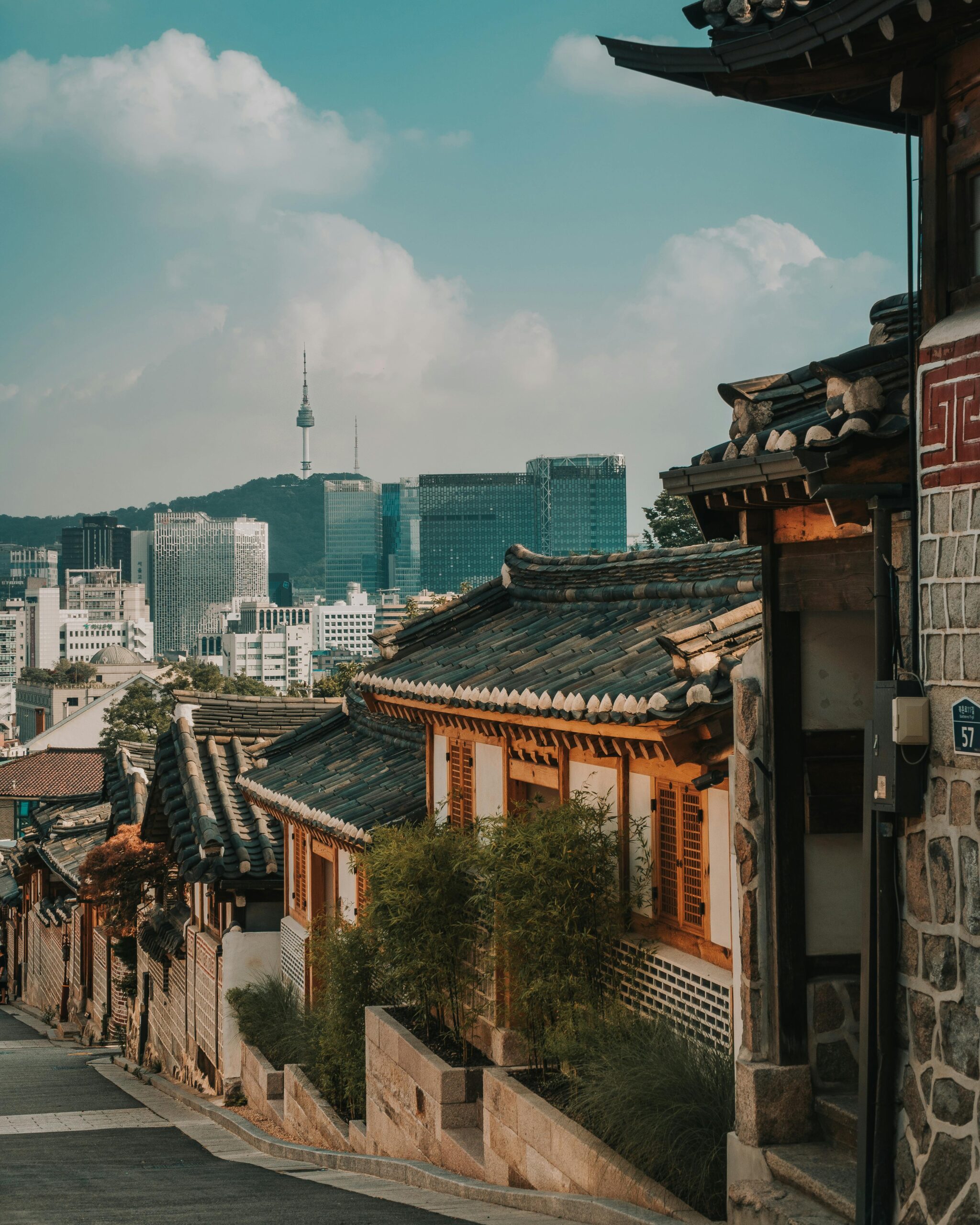 A street in Bukchon Hanok Village, Seoul, with Namsan Tower in the background.