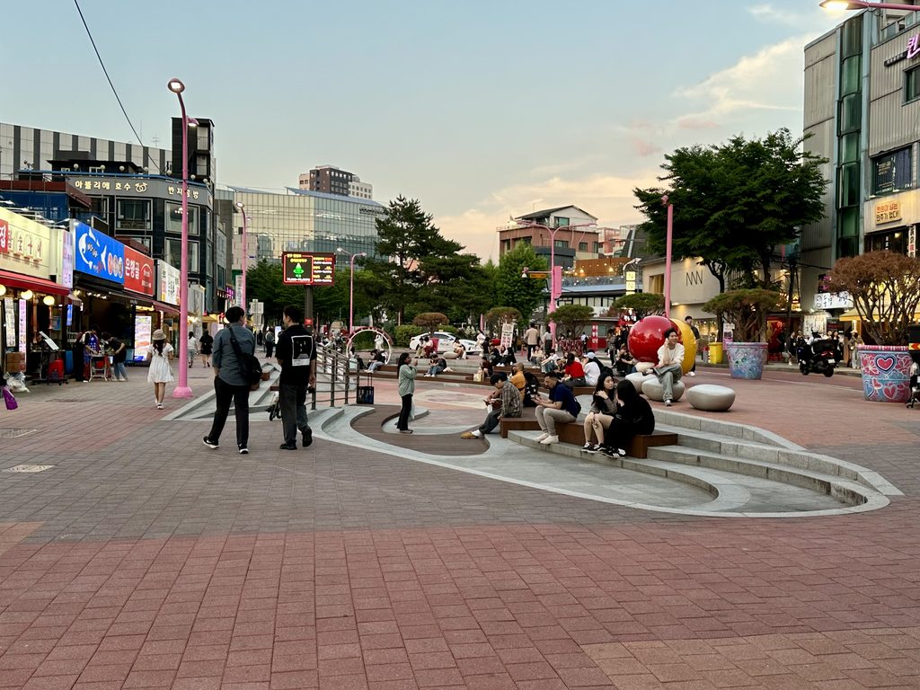 People walking along Hongdae Red Road in Seoul.